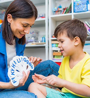 Speech therapist working with a happy young boy
