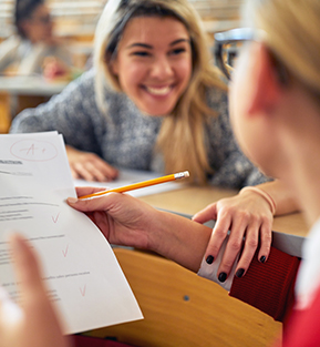 Happy teacher helping a student